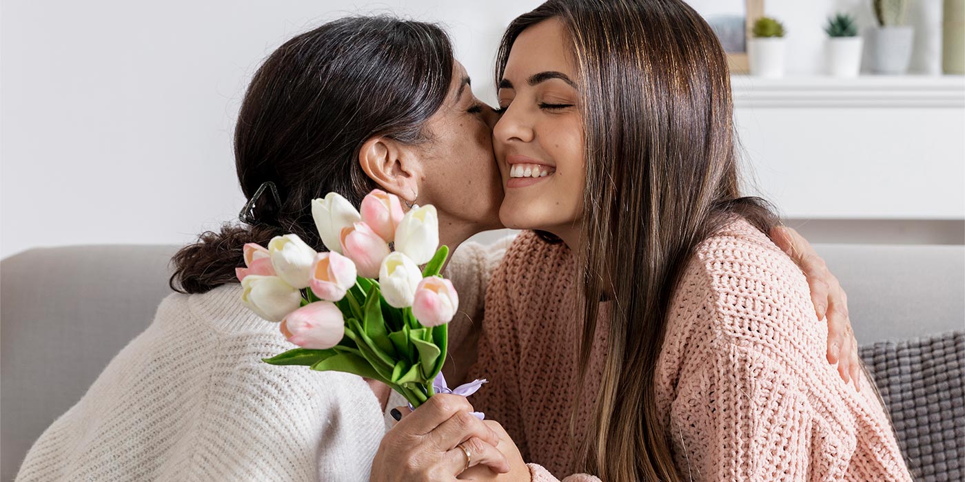 madre besando niña flores